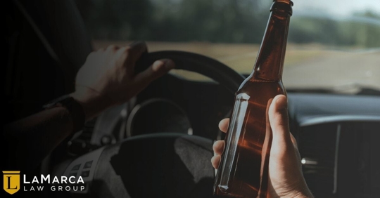 driver holding an alcoholic beverage