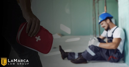 injured worker with a coworker bringing a first aid kit